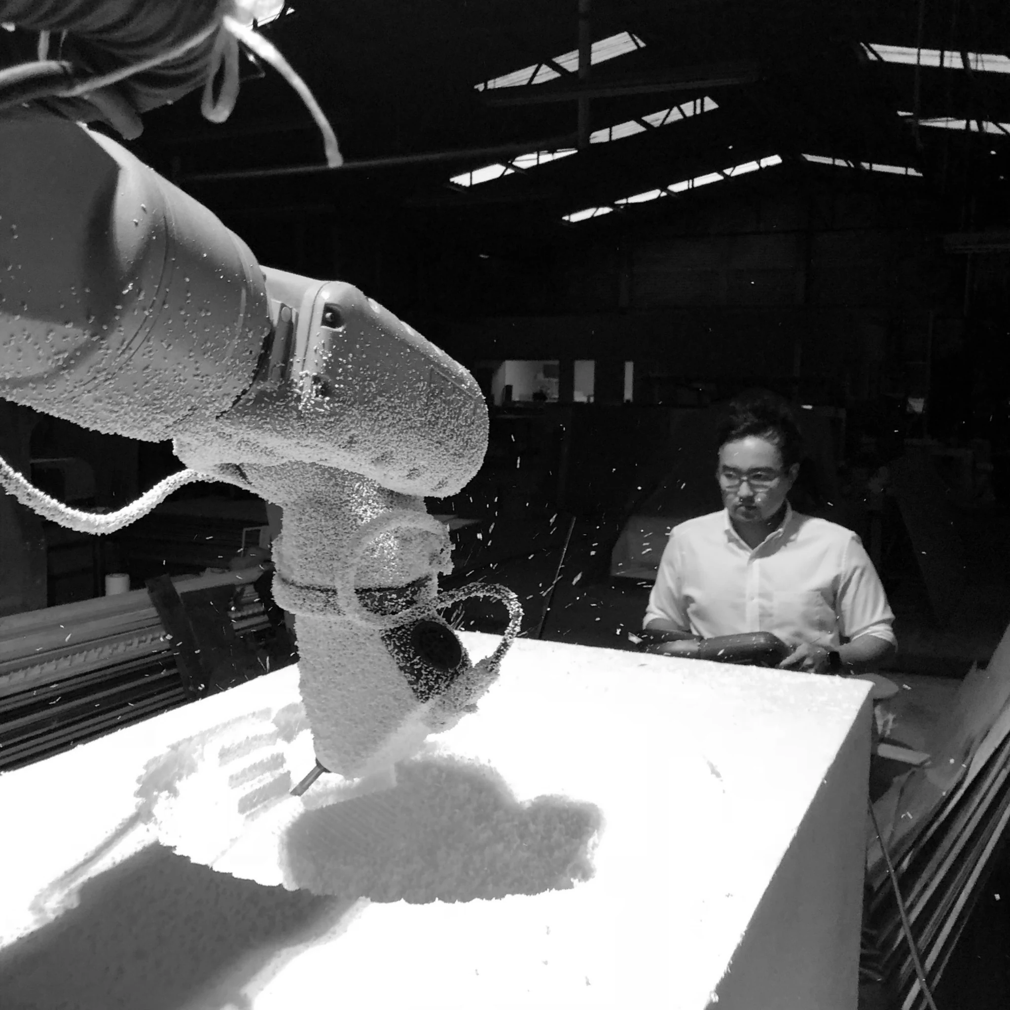 Yoshio Fukumori working beside a robotic arm during fabrication